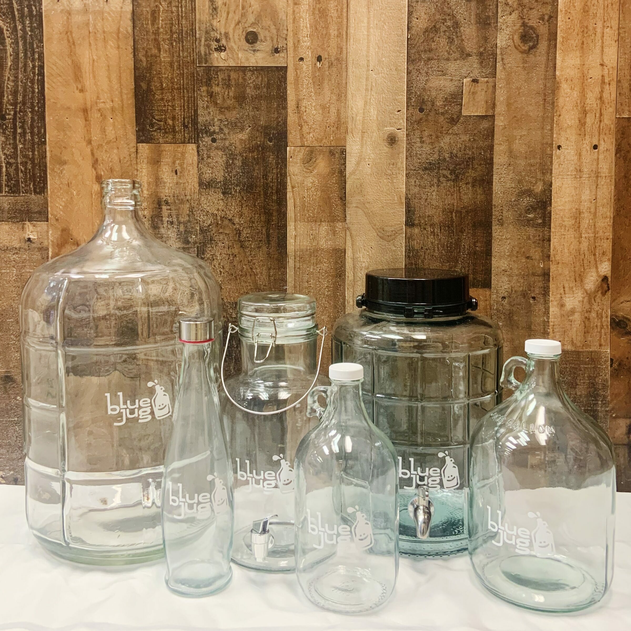 Glass jars with a distinctive blue jug logo imprinted on them, adding a touch of branding and style to the containers