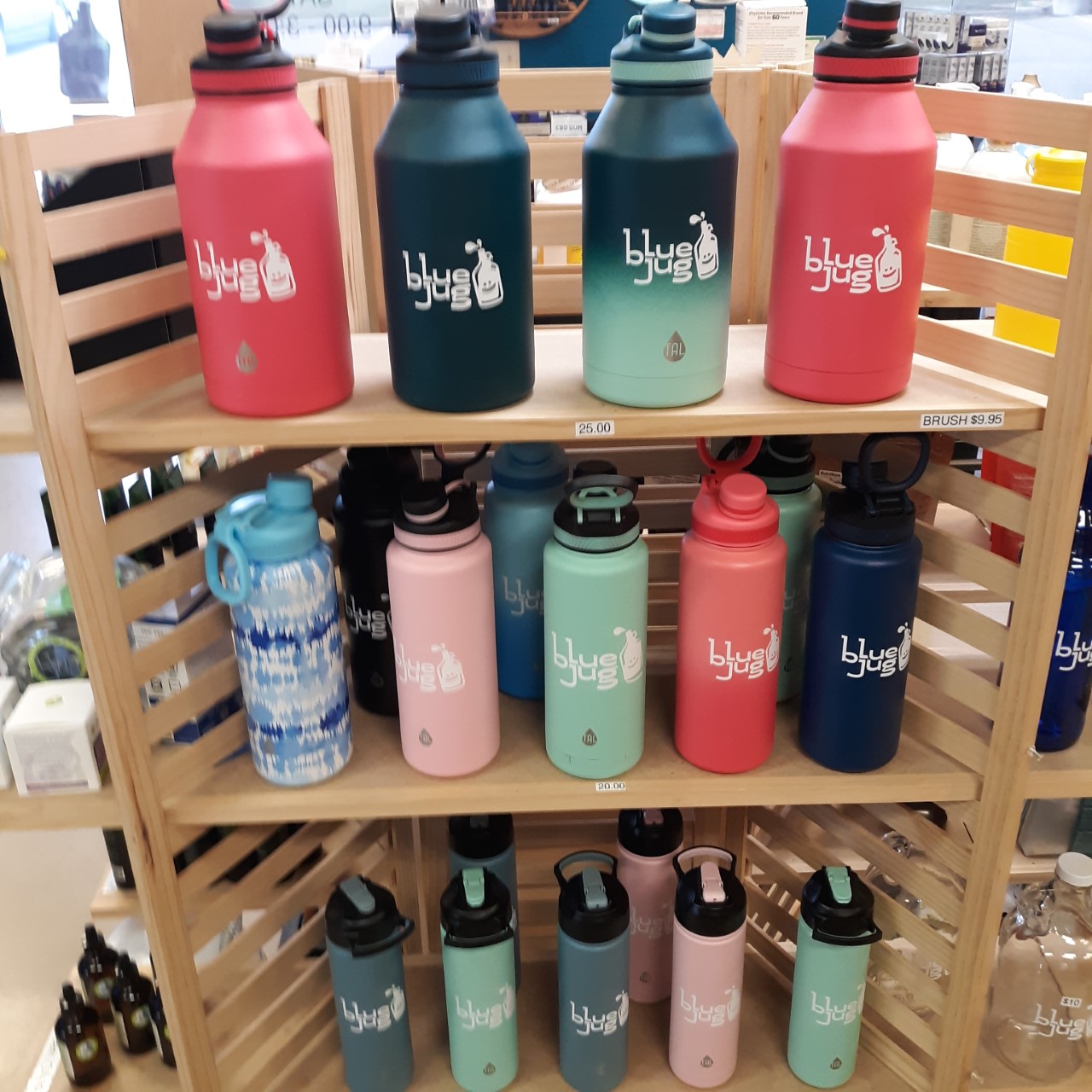 Assorted Blue Jug Waco drinking bottles displayed on a stand